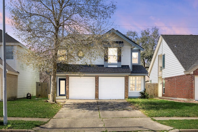 traditional home with driveway, a garage, brick siding, fence, and a front yard