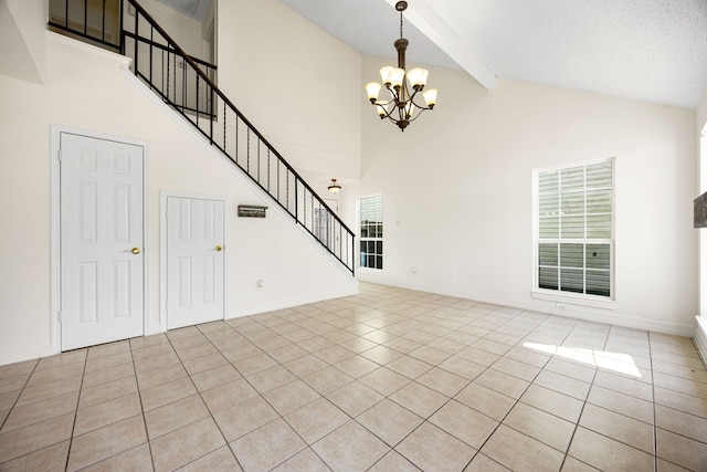 unfurnished living room with a chandelier, beamed ceiling, baseboards, and stairs