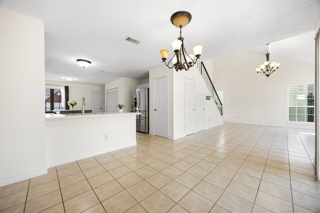 interior space featuring light tile patterned floors, visible vents, a sink, and an inviting chandelier