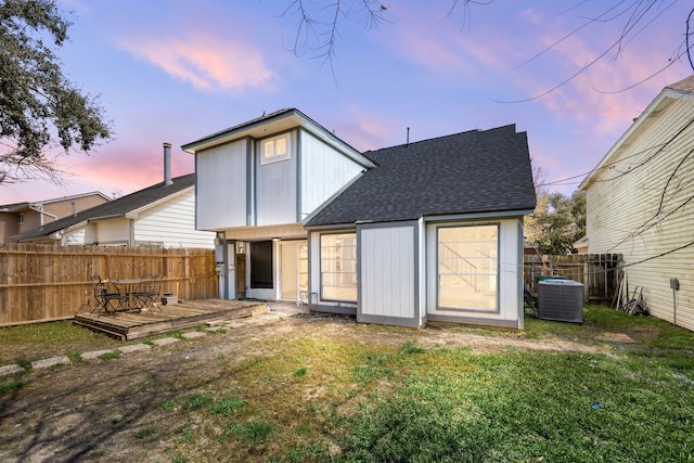 back of house with a lawn, fence, a deck, and central air condition unit