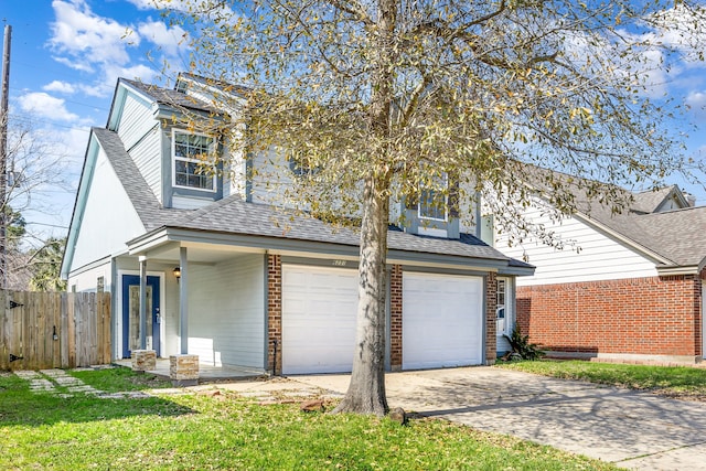 traditional-style home featuring a shingled roof, brick siding, fence, concrete driveway, and a front yard