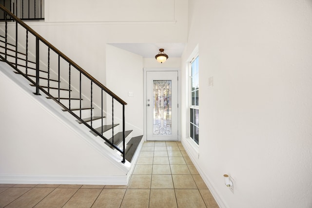 tiled foyer with stairway and baseboards