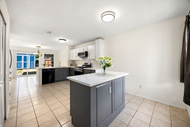 kitchen featuring visible vents, a peninsula, stainless steel appliances, light countertops, and light tile patterned flooring