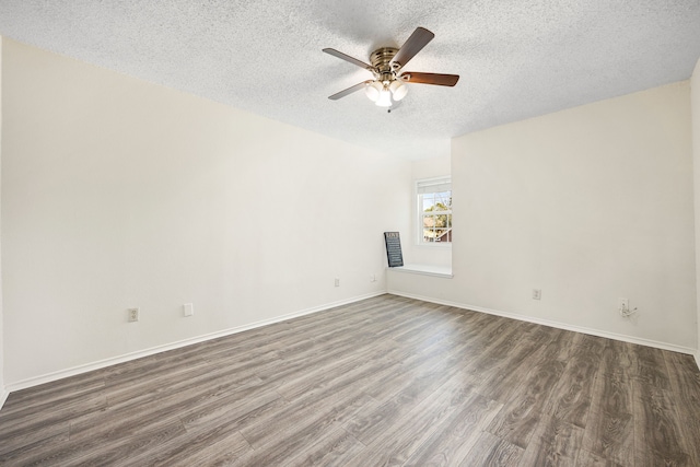 unfurnished room with dark wood-type flooring, a textured ceiling, baseboards, and a ceiling fan