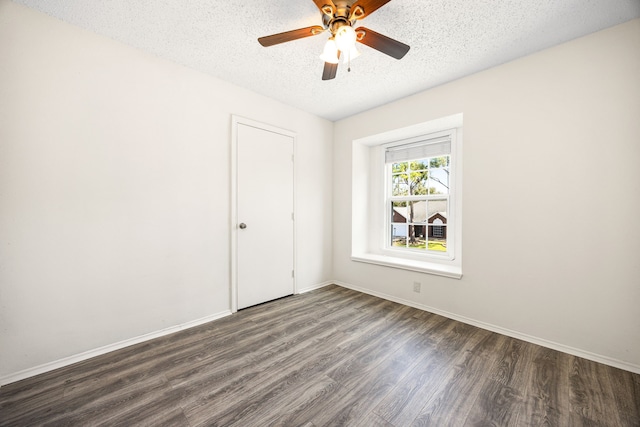 spare room with dark wood-style flooring, ceiling fan, a textured ceiling, and baseboards