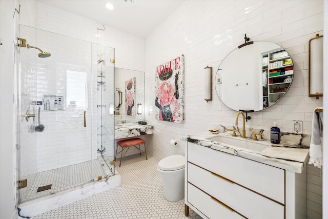 full bathroom with tile walls, toilet, a shower stall, vanity, and tile patterned floors