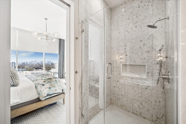 full bath featuring a notable chandelier, a stall shower, connected bathroom, and a city view