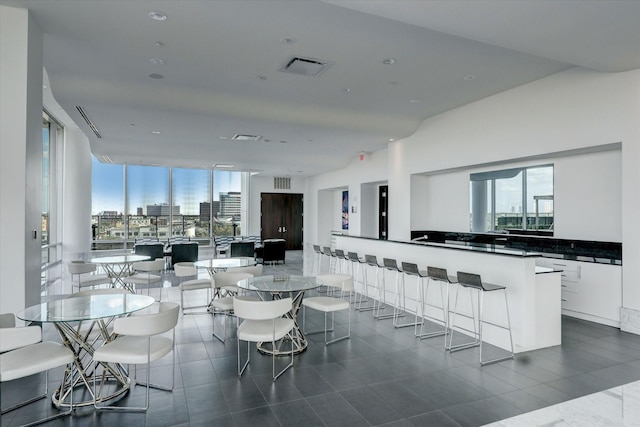 dining space with a healthy amount of sunlight, visible vents, and a city view