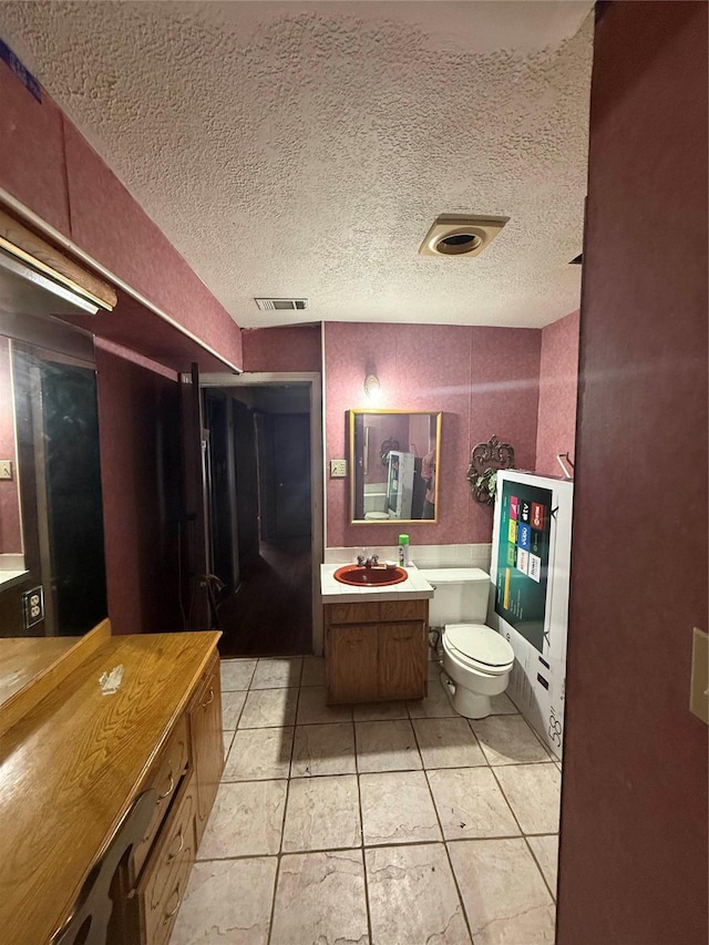 bathroom featuring visible vents, toilet, tile patterned flooring, a textured ceiling, and vanity