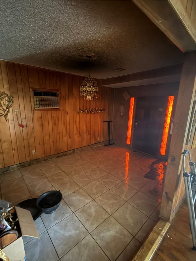 interior space with wooden walls, a textured ceiling, and a wall mounted air conditioner