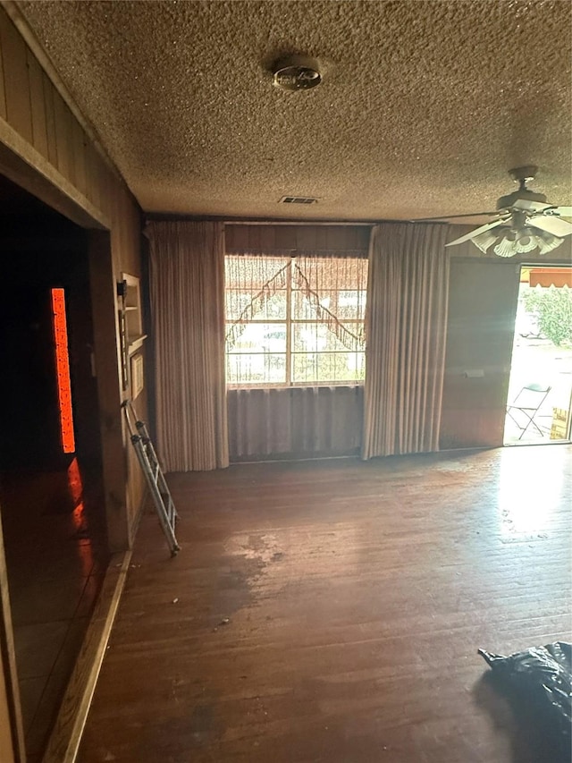 unfurnished room featuring a ceiling fan, a textured ceiling, and wood finished floors