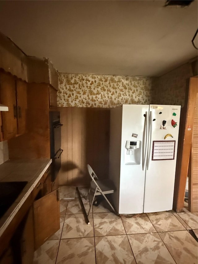 kitchen featuring white refrigerator with ice dispenser and oven