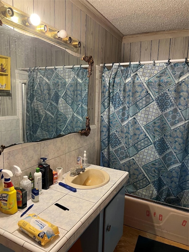 full bathroom with crown molding, shower / bath combination with curtain, tasteful backsplash, a textured ceiling, and vanity