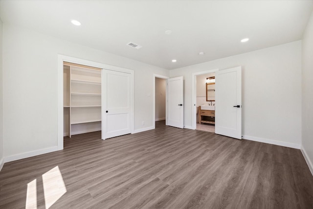 unfurnished bedroom with recessed lighting, a closet, visible vents, wood finished floors, and baseboards