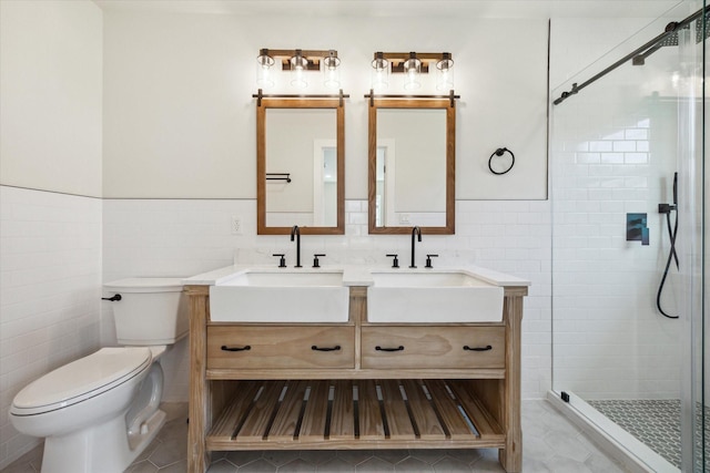 bathroom with a sink, a shower stall, and toilet