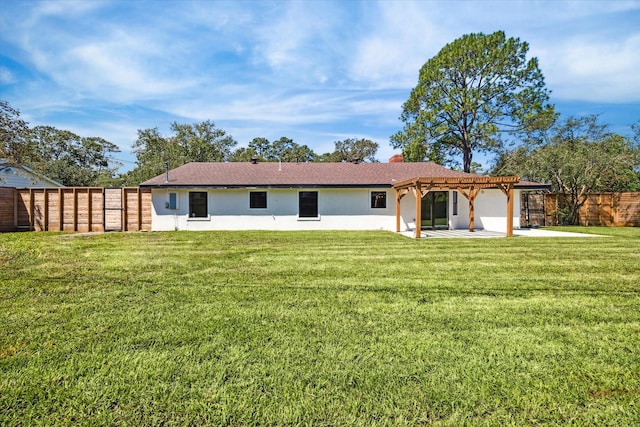 rear view of house with a yard, stucco siding, a patio area, a pergola, and a fenced backyard