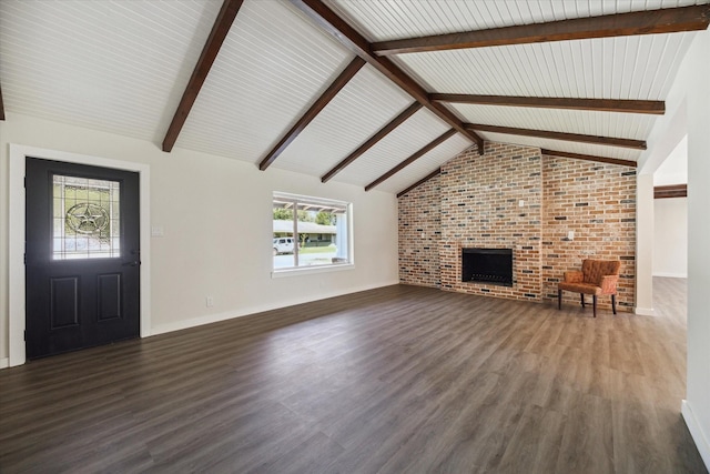 unfurnished living room featuring dark wood-style floors, lofted ceiling with beams, and a brick fireplace