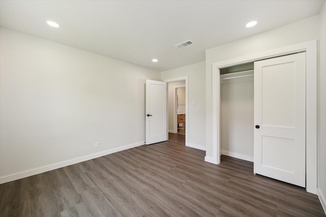 unfurnished bedroom with recessed lighting, dark wood-type flooring, visible vents, baseboards, and a closet