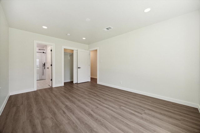 unfurnished bedroom with recessed lighting, wood finished floors, visible vents, and baseboards