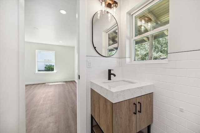 bathroom with tile walls, vanity, recessed lighting, and wood finished floors