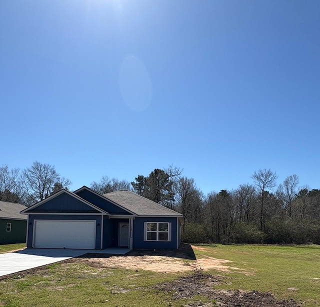 view of front of house featuring a garage, concrete driveway, and a front yard