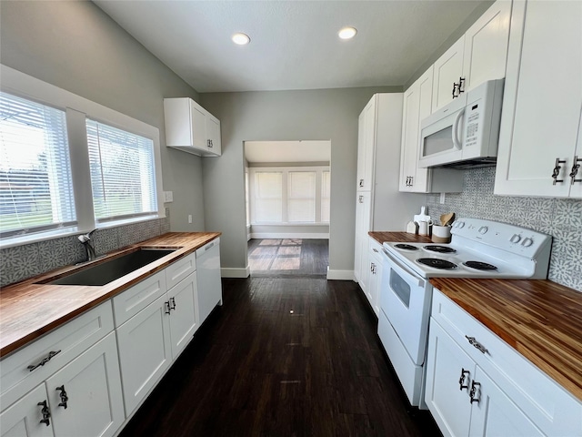 kitchen featuring white appliances, a sink, baseboards, wooden counters, and tasteful backsplash