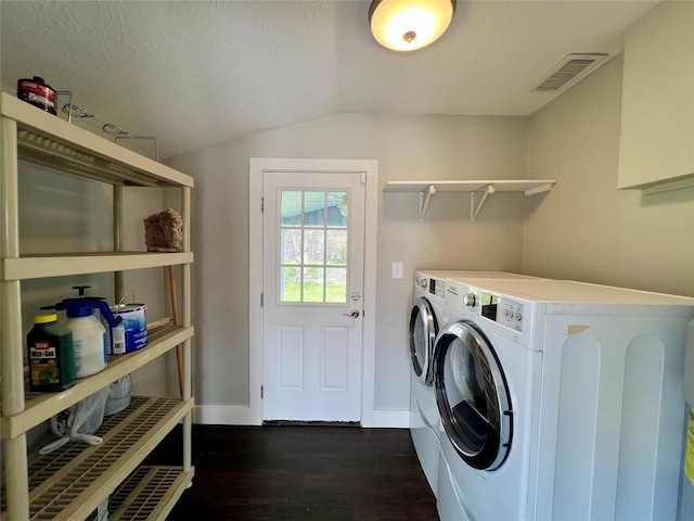 laundry area featuring washing machine and dryer, laundry area, dark wood-style flooring, visible vents, and baseboards