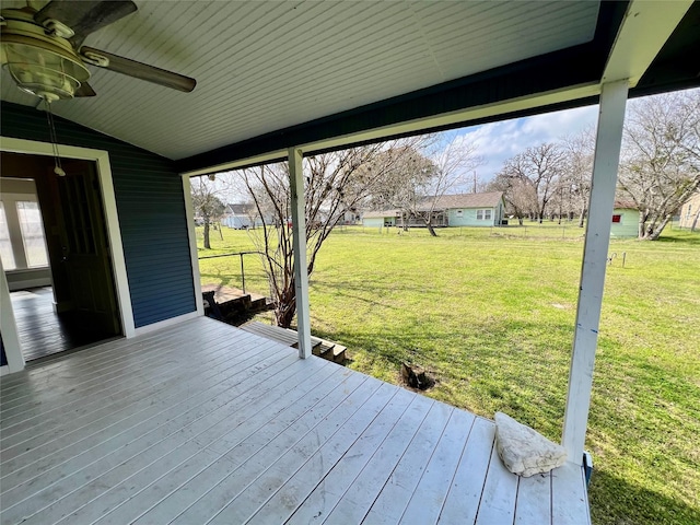 wooden deck featuring a lawn and ceiling fan