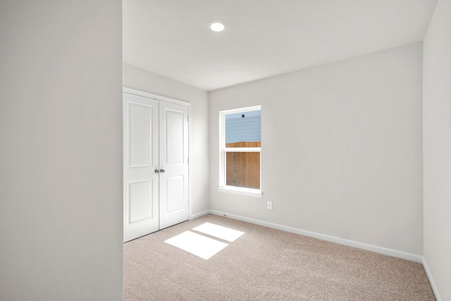 unfurnished bedroom with a closet, baseboards, and carpet flooring