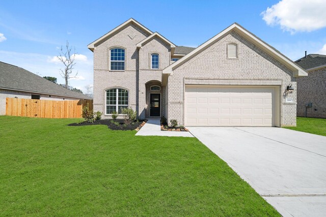 289 Galant Fox Way, New Caney, TX 77357 - view of front of property featuring an attached garage, brick siding, a front yard, and fence