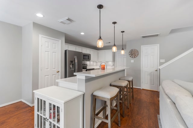 kitchen with stainless steel appliances, light countertops, visible vents, and white cabinets