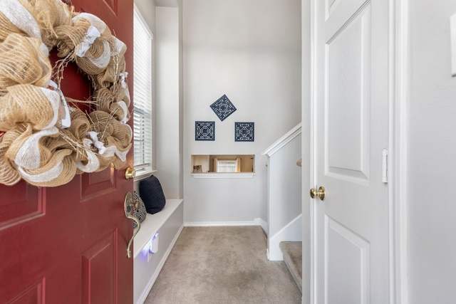 mudroom featuring baseboards and light colored carpet