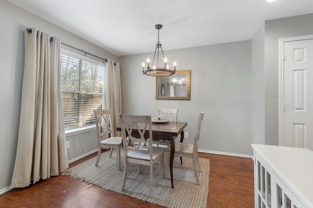 dining space with baseboards, a chandelier, and dark wood-style flooring