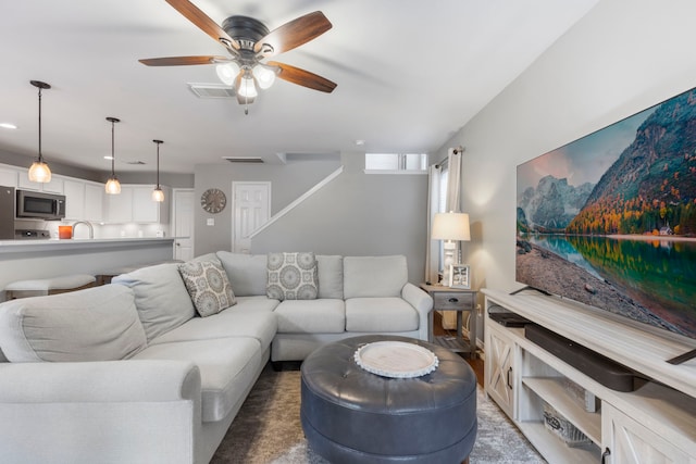 living area featuring a ceiling fan and visible vents