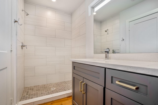 bathroom featuring tiled shower and vanity