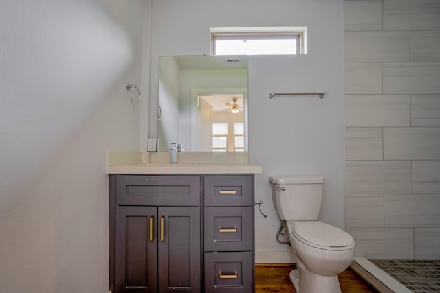 bathroom with toilet, plenty of natural light, wood finished floors, and vanity