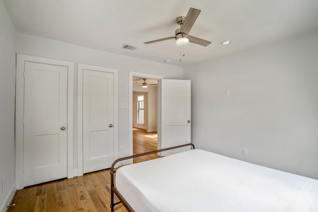 bedroom with a ceiling fan, visible vents, and light wood-style floors