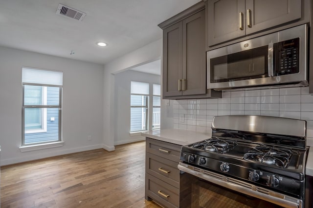 kitchen featuring visible vents, appliances with stainless steel finishes, and gray cabinets