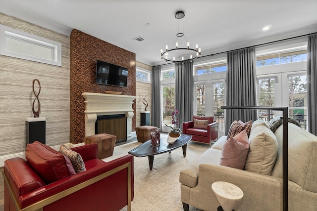 interior space featuring wallpapered walls, a fireplace, visible vents, and a notable chandelier