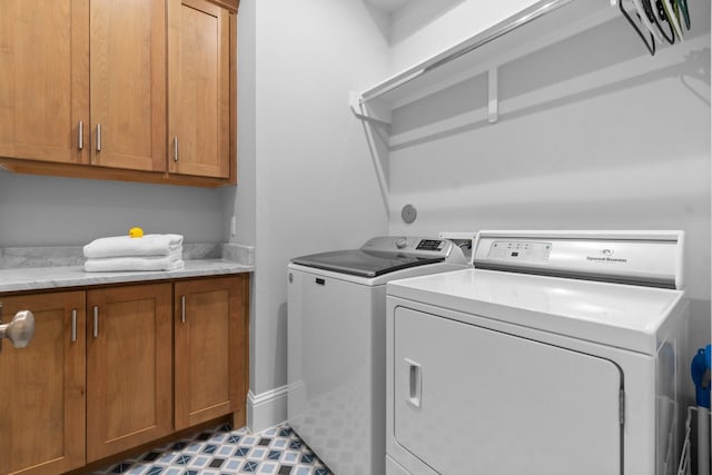 laundry room with cabinet space, washer and clothes dryer, and tile patterned floors