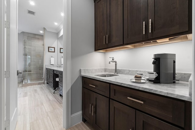 bar with recessed lighting, visible vents, ornamental molding, a sink, and baseboards