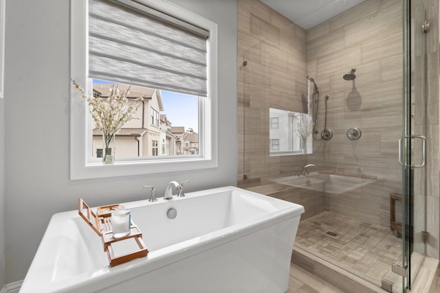 bathroom with a soaking tub and a shower stall