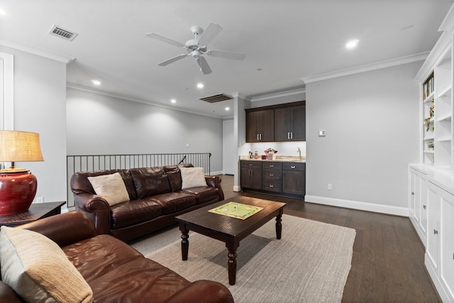 living area with dark wood-style floors, wet bar, visible vents, and baseboards