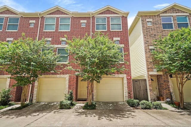 8705 Bryam Unit 104, Houston, TX 77061 - view of property featuring driveway, brick siding, and an attached garage