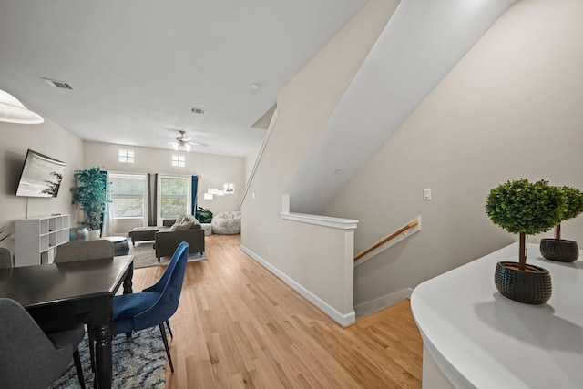 dining area featuring baseboards, a ceiling fan, visible vents, and light wood-style floors