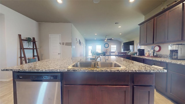 kitchen featuring recessed lighting, stainless steel dishwasher, open floor plan, a kitchen island with sink, and a sink