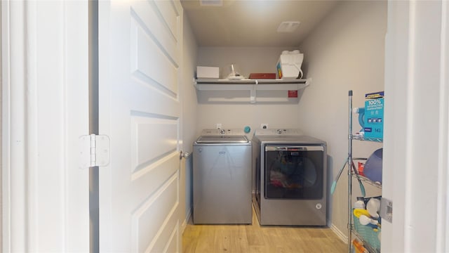 washroom featuring laundry area, washer and clothes dryer, and light wood-style floors