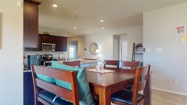 dining space with light wood-type flooring, baseboards, and recessed lighting
