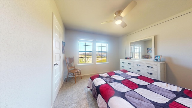 bedroom featuring light colored carpet, ceiling fan, and baseboards