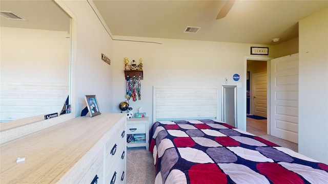 carpeted bedroom with a ceiling fan and visible vents